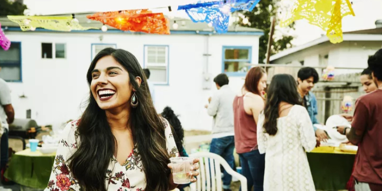 A joyful woman toasting with friends at her housewarming celebration