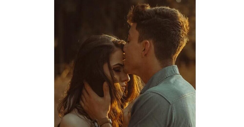 Romantic couple in an intimate moment with golden warm lighting, representing healthy relationship and love