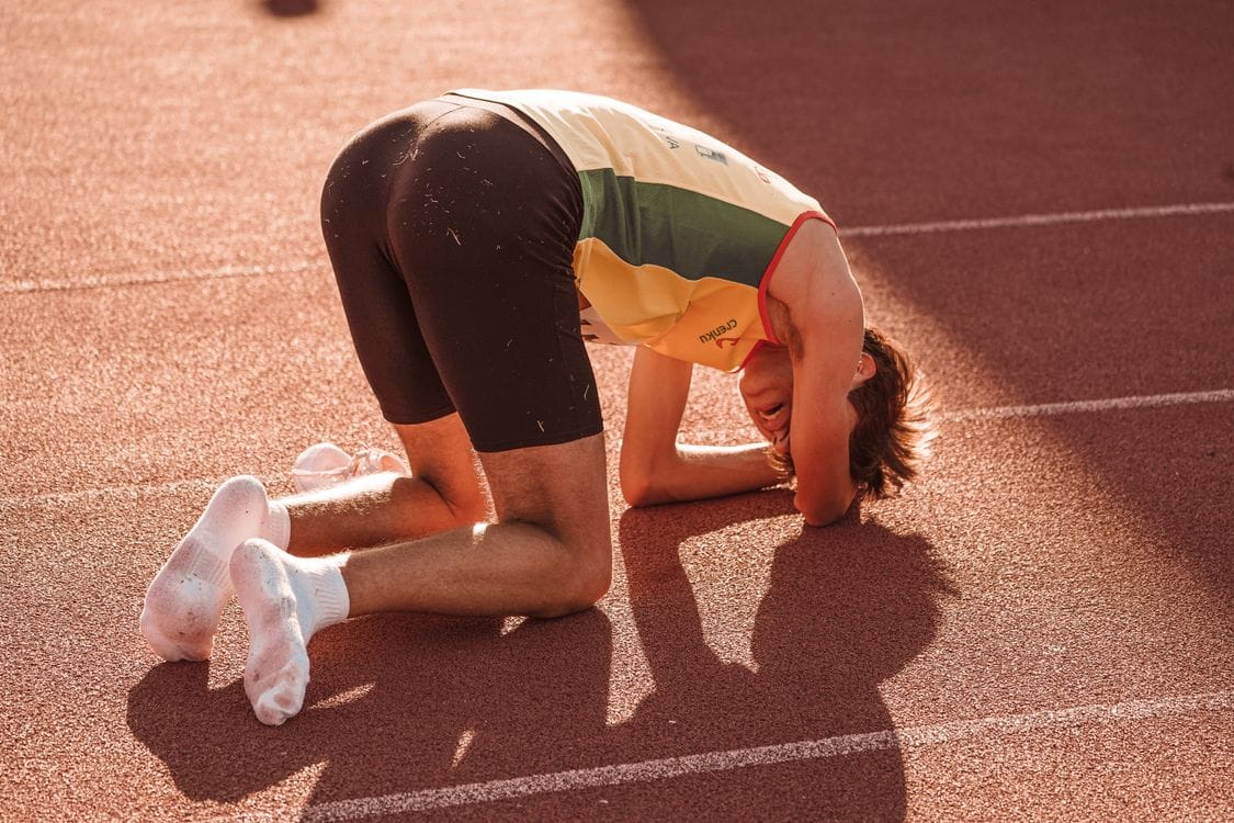 athlete kneeling on track — how to lose gracefully with dignity and strength