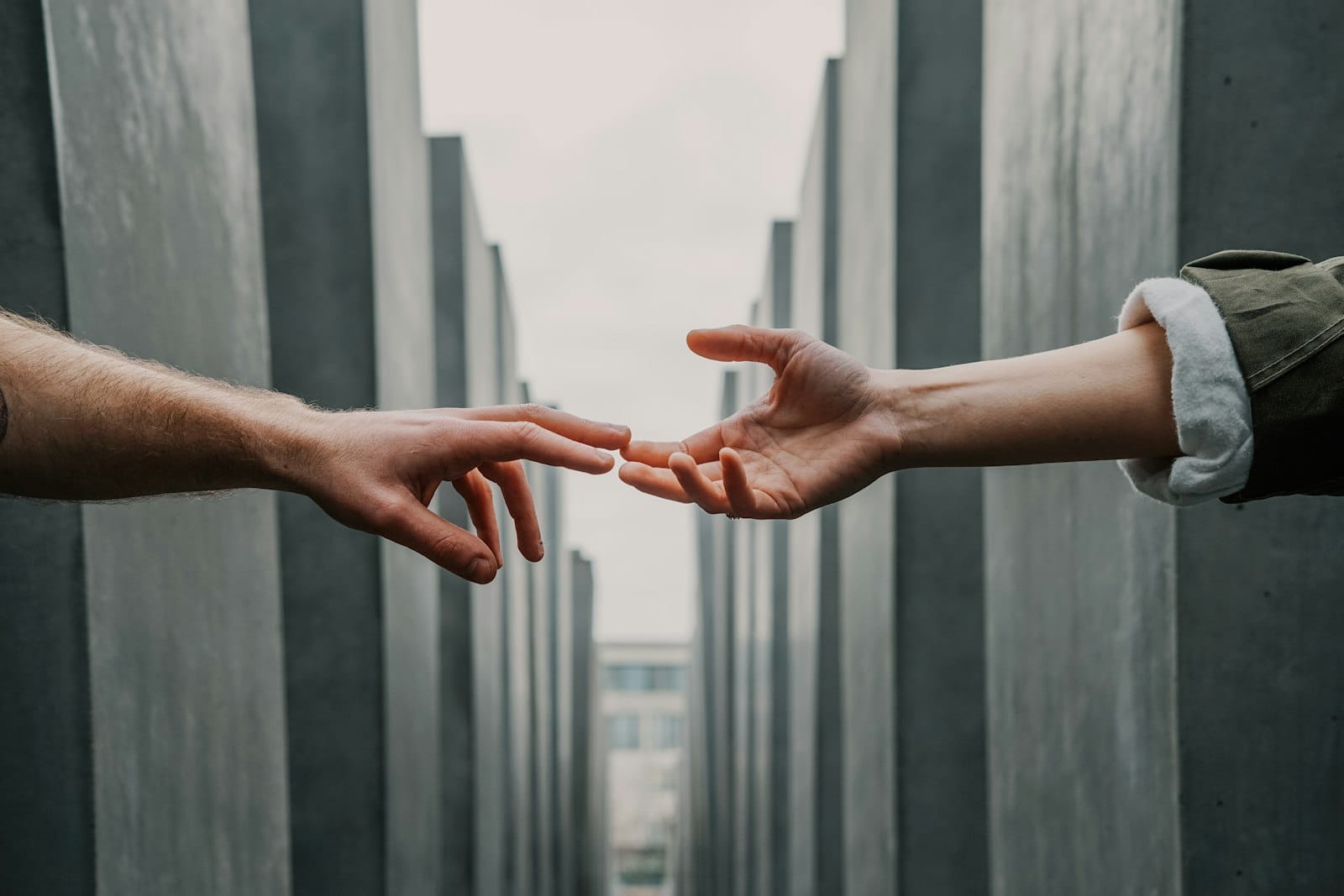 Two hands reaching toward each other but not quite touching, symbolising emotional distance